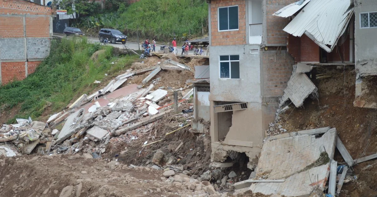 Un edificio residencial colapsado parcialmente debido a un desastre natural, mostrando daños estructurales graves.