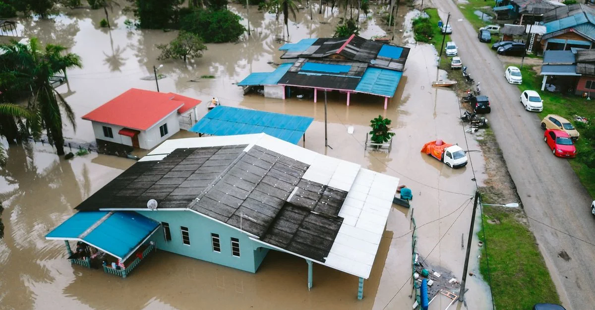 Vista aérea de un pueblo inundado en Kijal, Terengganu, Malasia, mostrando casas y calles sumergidas.