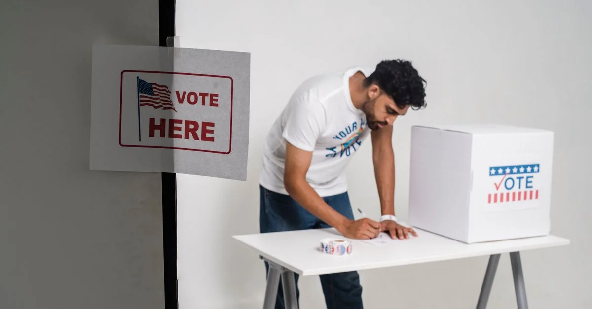 Un hombre emitendo su voto en una urna, destacando el proceso democrático en un entorno de estudio.