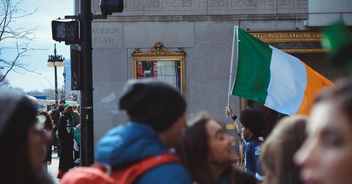 La multitud celebra el Día de San Patricio en Chicago con banderas irlandesas y un ambiente festivo.