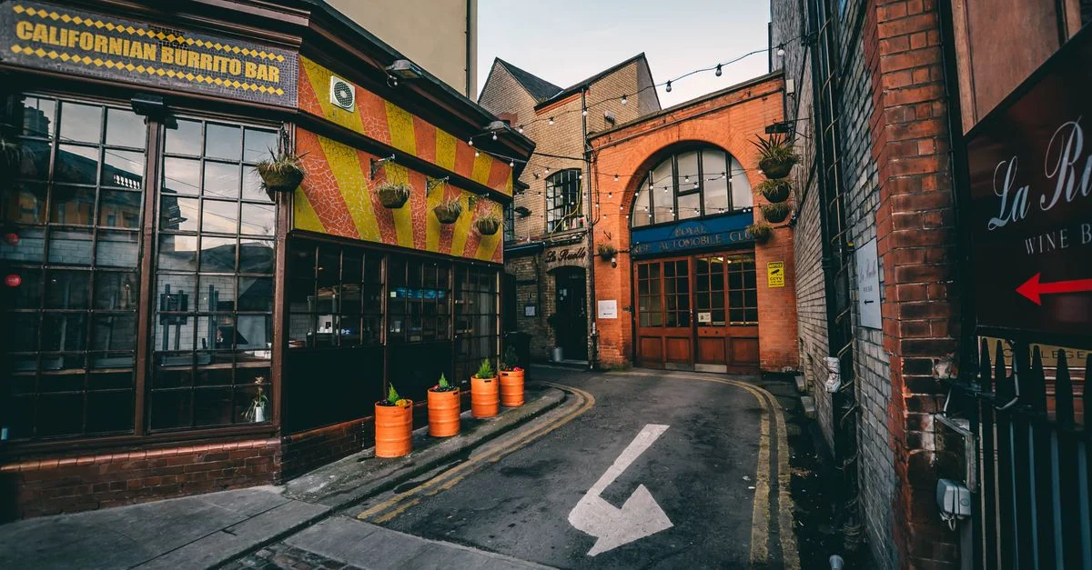 Un callejón vibrante en Dublín con tiendas locales y arquitectura rústica.